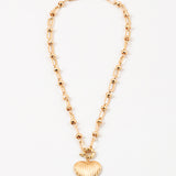 Gold necklace with a heart-shaped pendant on a white background