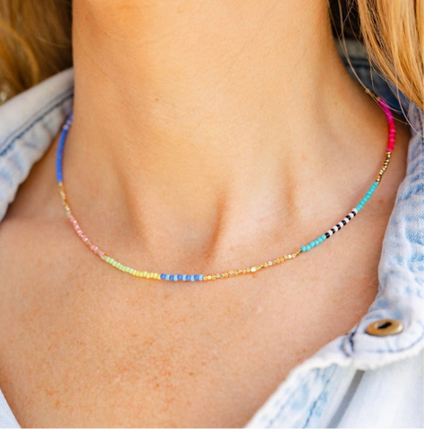 A woman wearing a thin colorful beaded short necklace