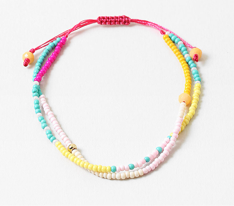 Bracelet made of double strands of beads in pinks, teals, whites and yellows.