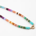Picture of a bead necklace in oranges, purples, greens and blues with a gold toggle clasp.