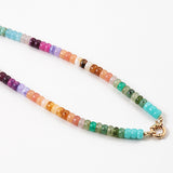 Picture of a bead necklace in oranges, purples, greens and blues with a gold toggle clasp.