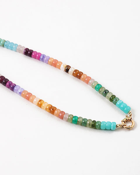 Picture of a bead necklace in oranges, purples, greens and blues with a gold toggle clasp.