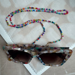 Picture of a multicolored beaded lanyard used as a sunglasses holder.