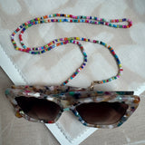 Picture of a multicolored beaded lanyard used as a sunglasses holder.