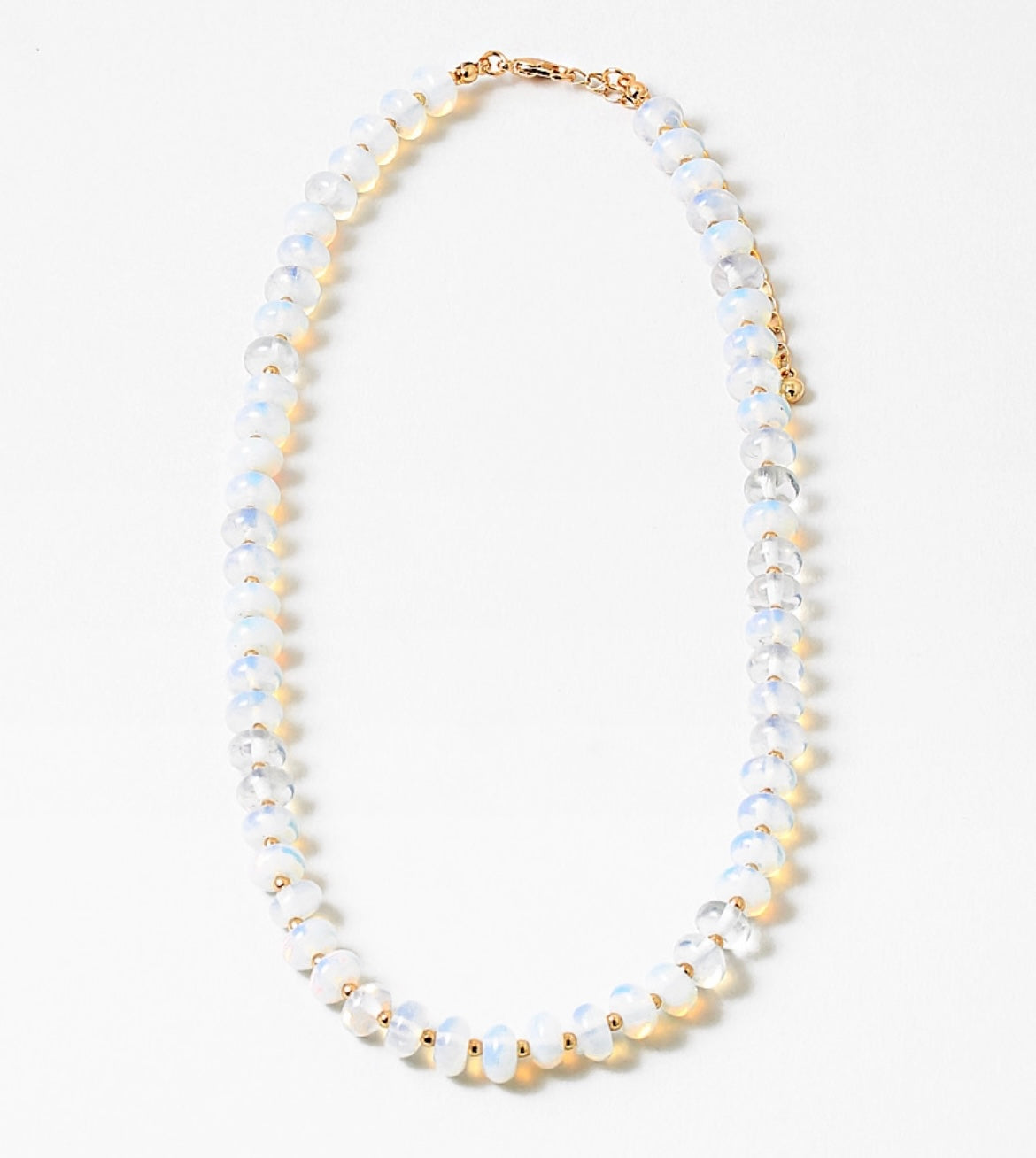Necklace with opaque white and gold beads on a white background