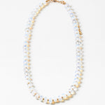 Necklace with opaque white and gold beads on a white background