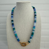 Necklace of shades of dark and light blue beads with a gold clasp.