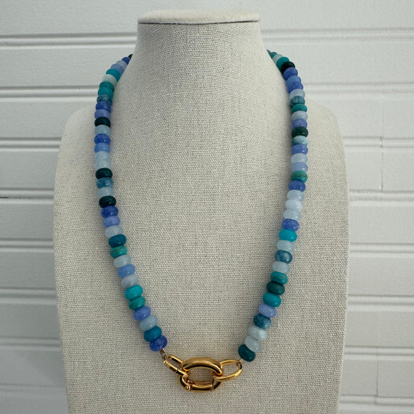 Necklace of shades of dark and light blue beads with a gold clasp.