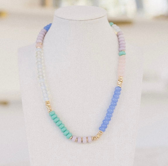 Beaded necklaces in clear, green, blue and pink beads with accenting gold beads.