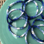 Picture of a green plate holding 8 blue ombre bead bracelets