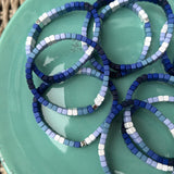 Picture of a green plate holding 8 blue ombre bead bracelets