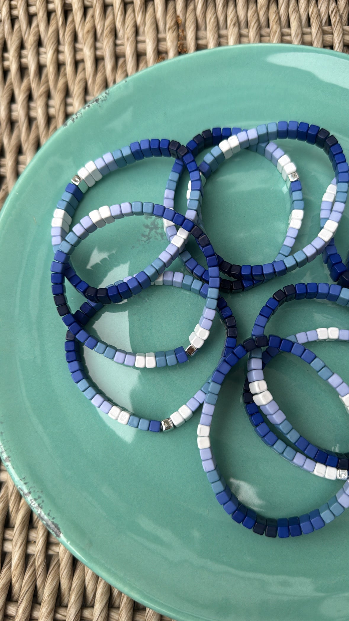 Picture of a green plate holding 8 blue ombre bead bracelets