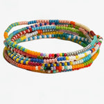 Set of 7 colorful stretch beaded bracelets on a white background