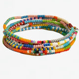 Set of 7 colorful stretch beaded bracelets on a white background