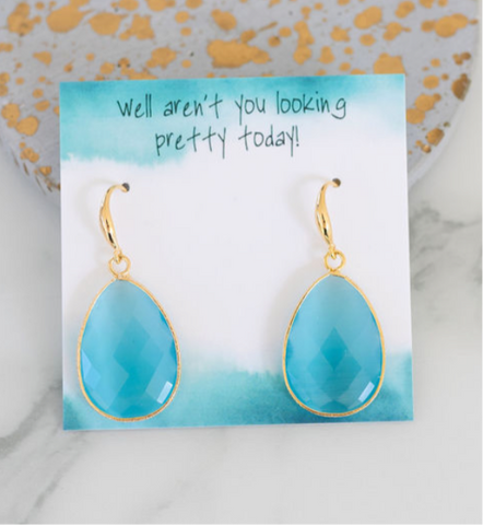 Picture of a pair of dangle earrings with teardrop shaped light blue cut stone earrings