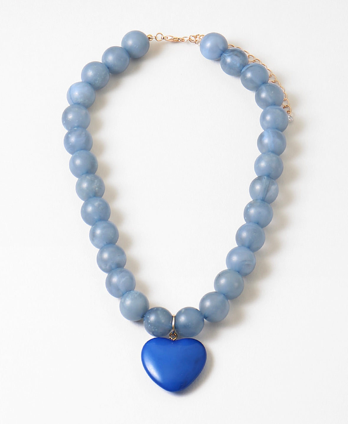 Necklace with blue beads and a blue heart-shaped pendant on a white background