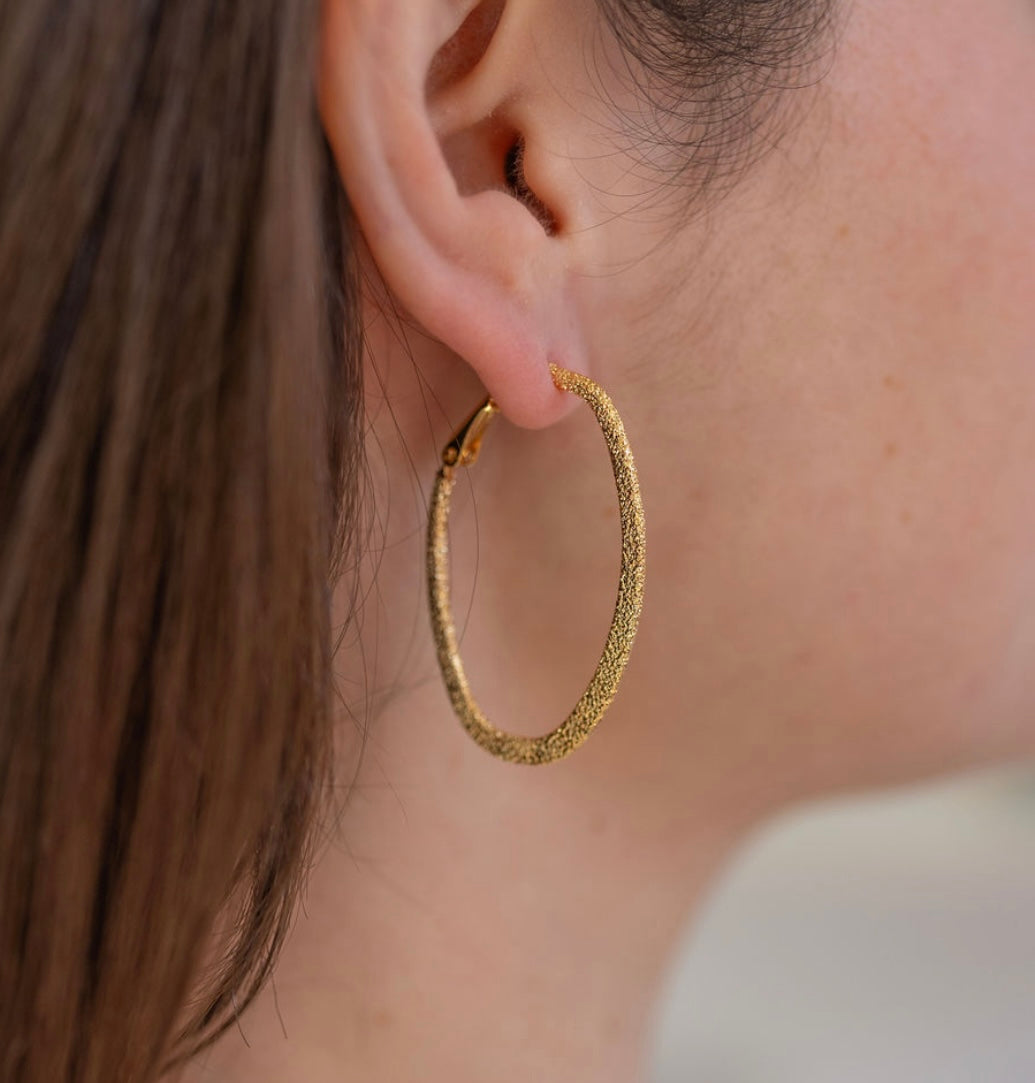 Picture of model wearing a textured gold hoops