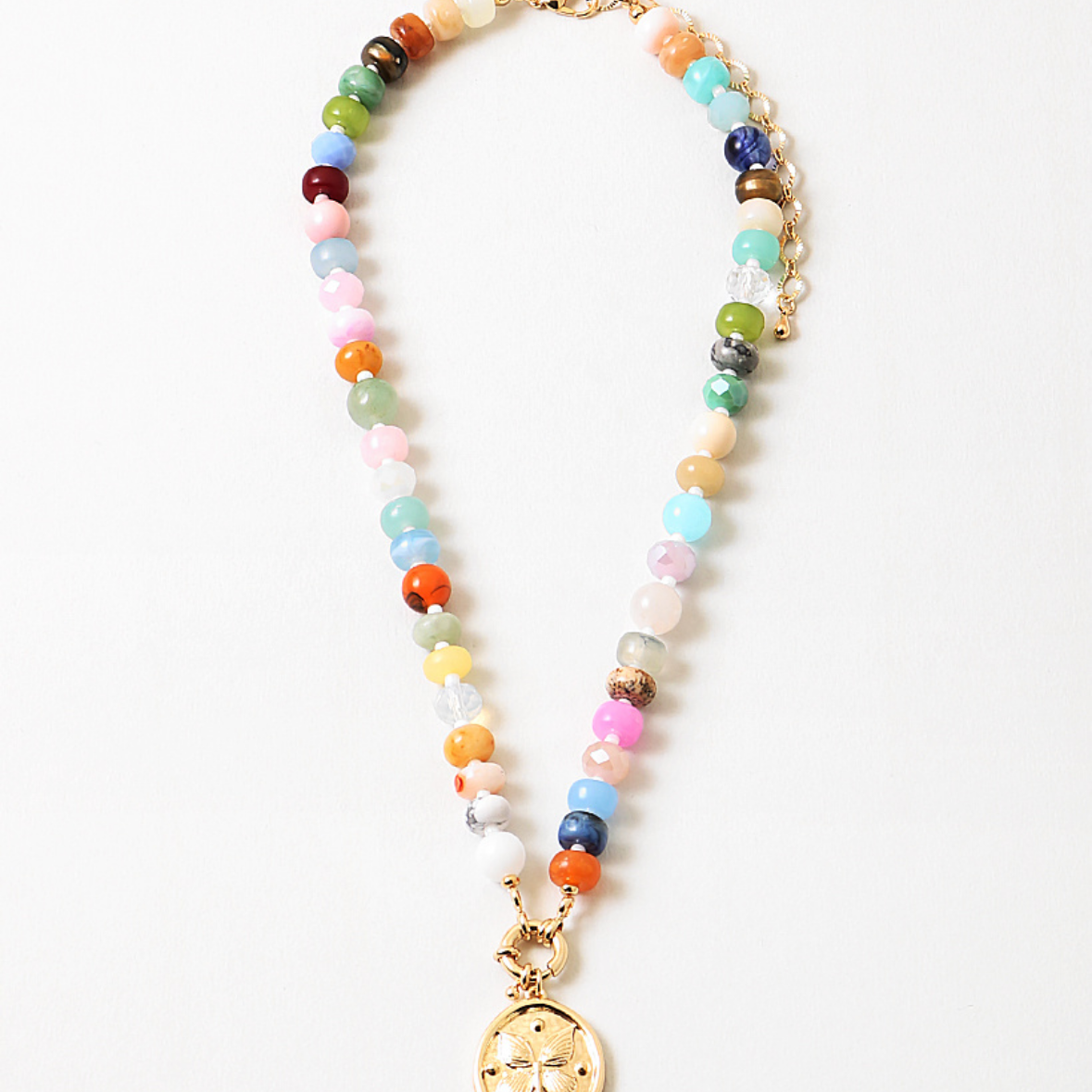 Multicolor bead necklace with a large central clasp and a butterfly disc pendant.