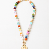 Multicolor bead necklace with a large central clasp and a butterfly disc pendant.