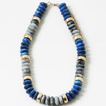 A necklace with blue resin beads and gold-tone accents, displayed against a white background.