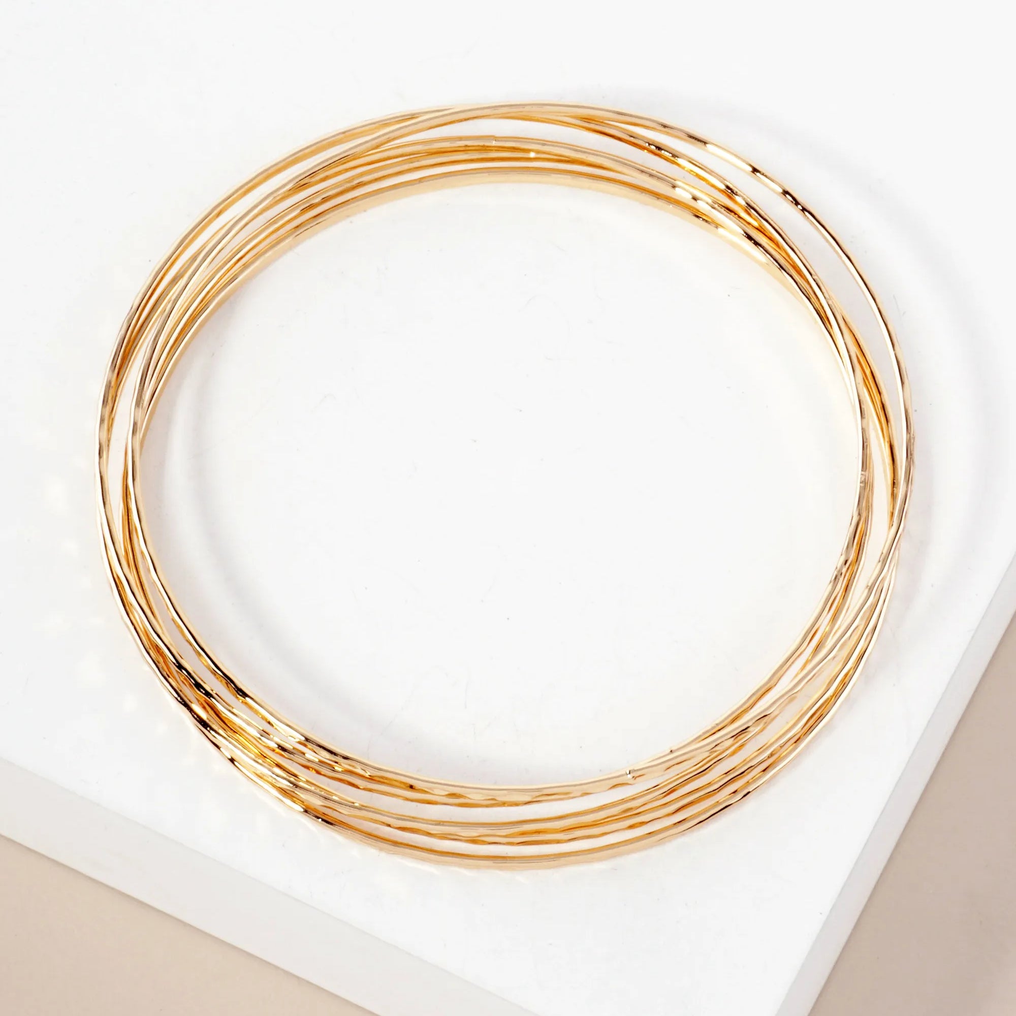 Set of five delicate gold bangles.