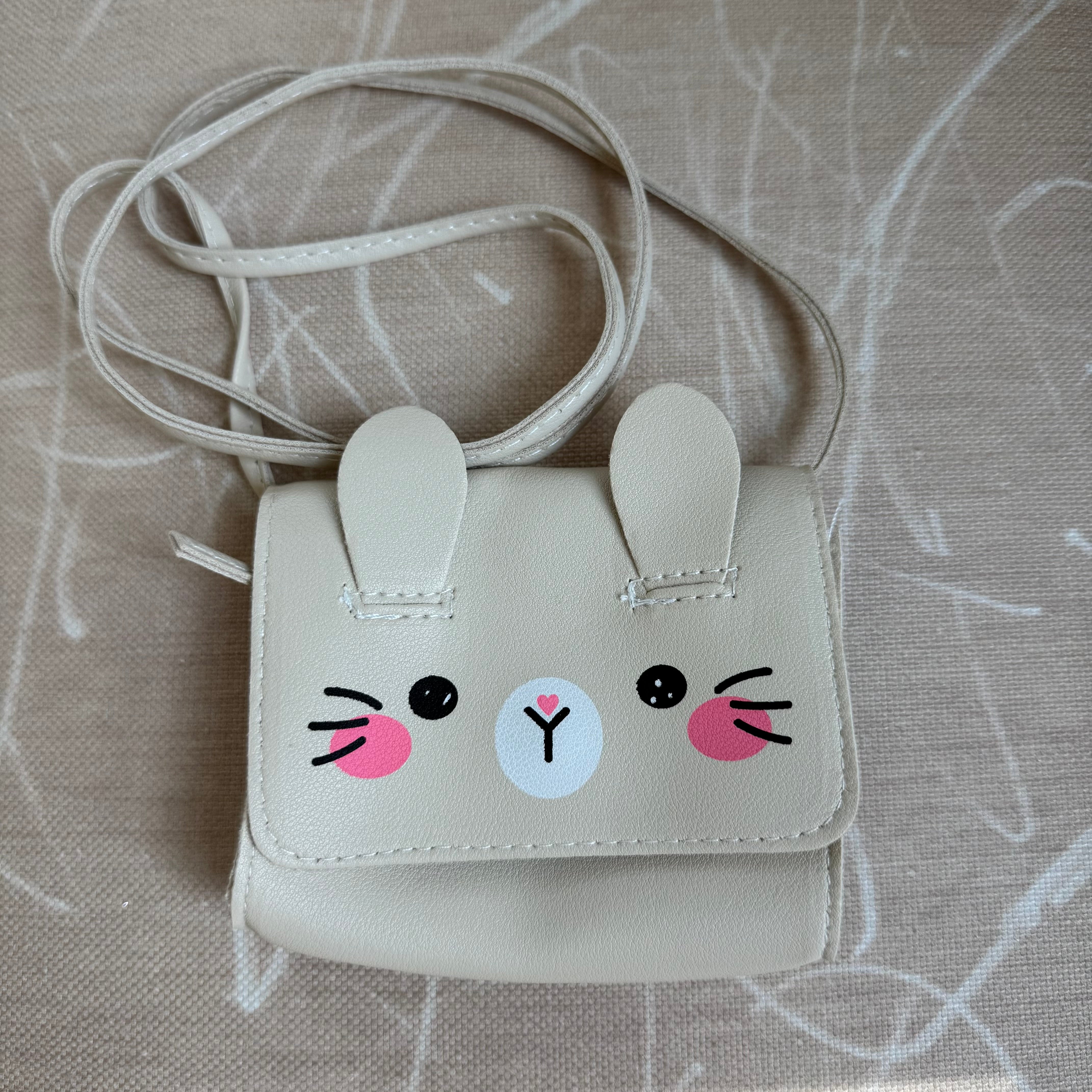 Picture of a little girl's purse. Purse is made to look like a sparkly cream colored bunny face.