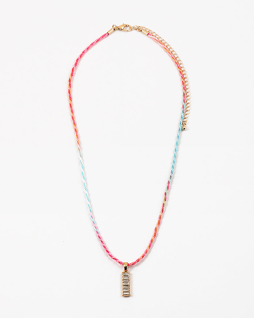 Necklace with colorful cord and gold rectangle pendant on a white background