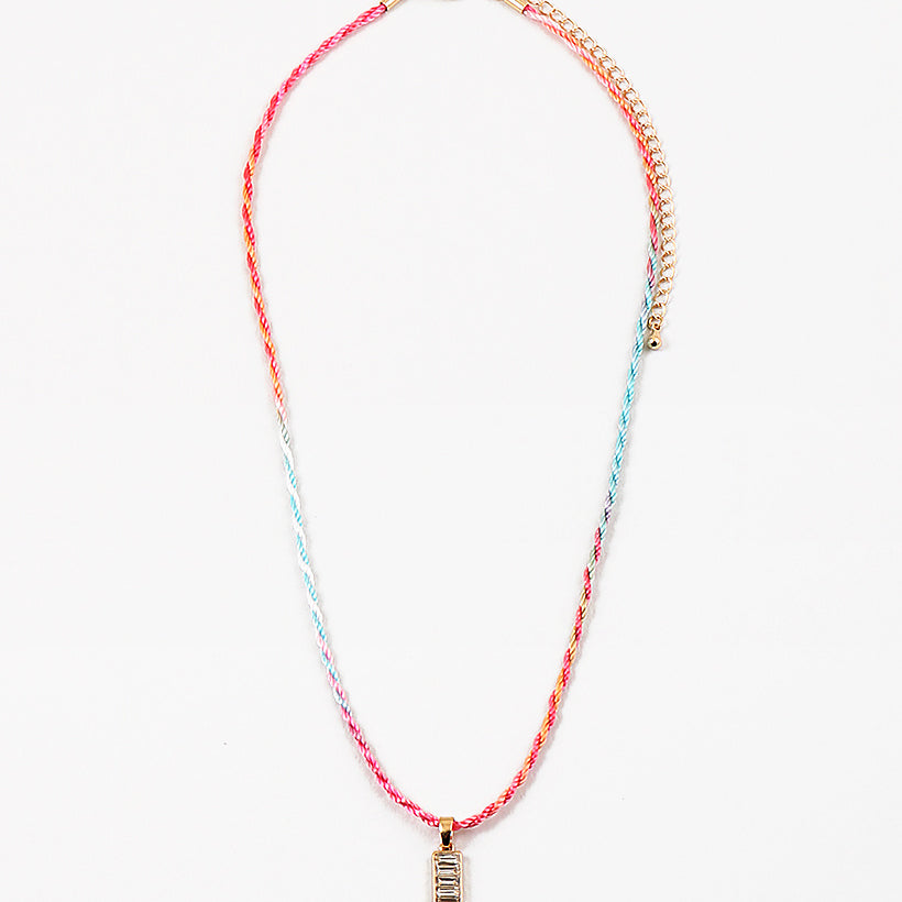 Necklace with colorful cord and gold rectangle pendant on a white background