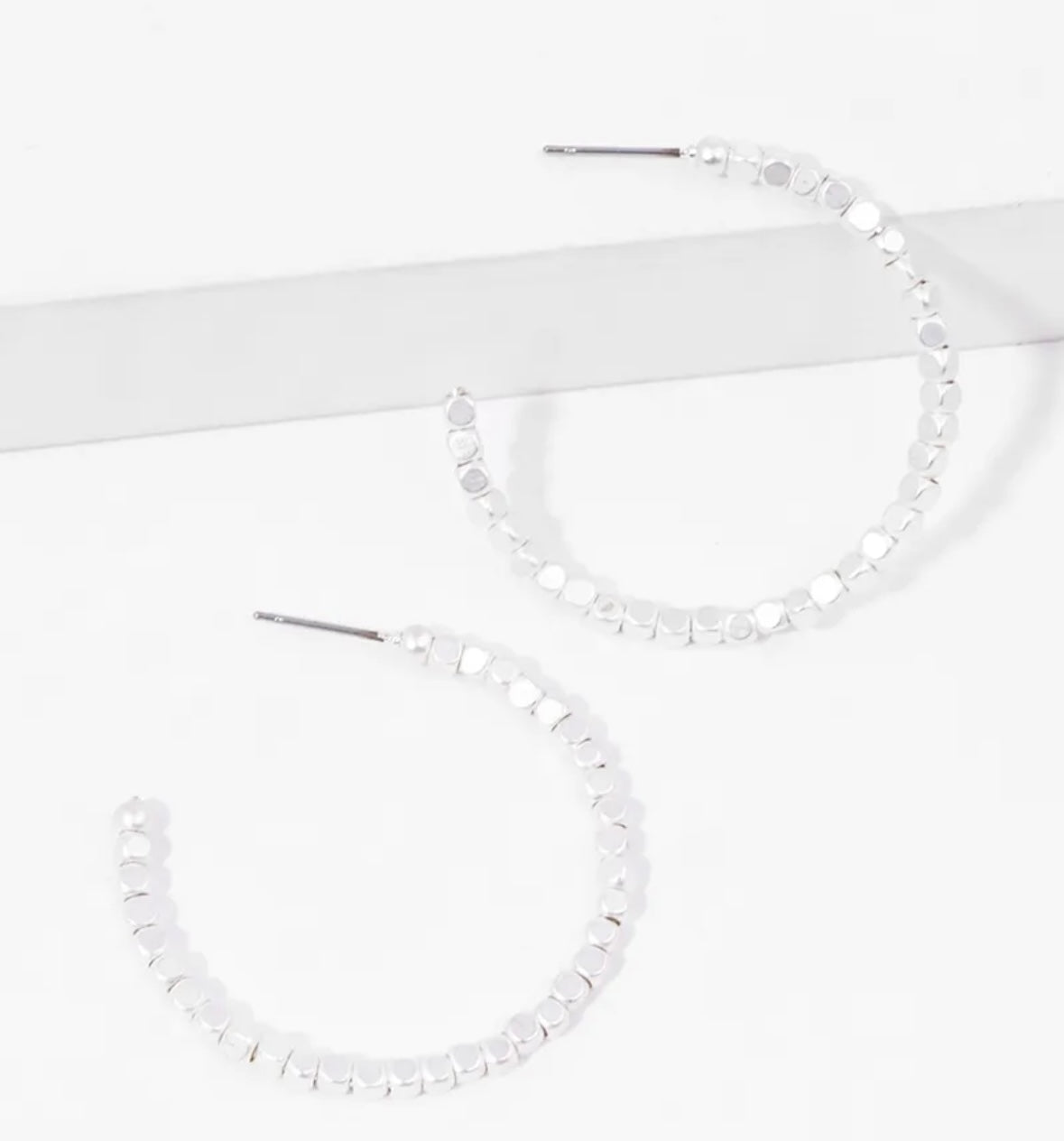 Picture of a set of white bead hoop earrings.