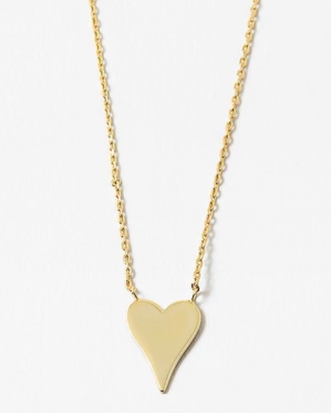 Gold heart-shaped pendant on a delicate gold necklace on a white background