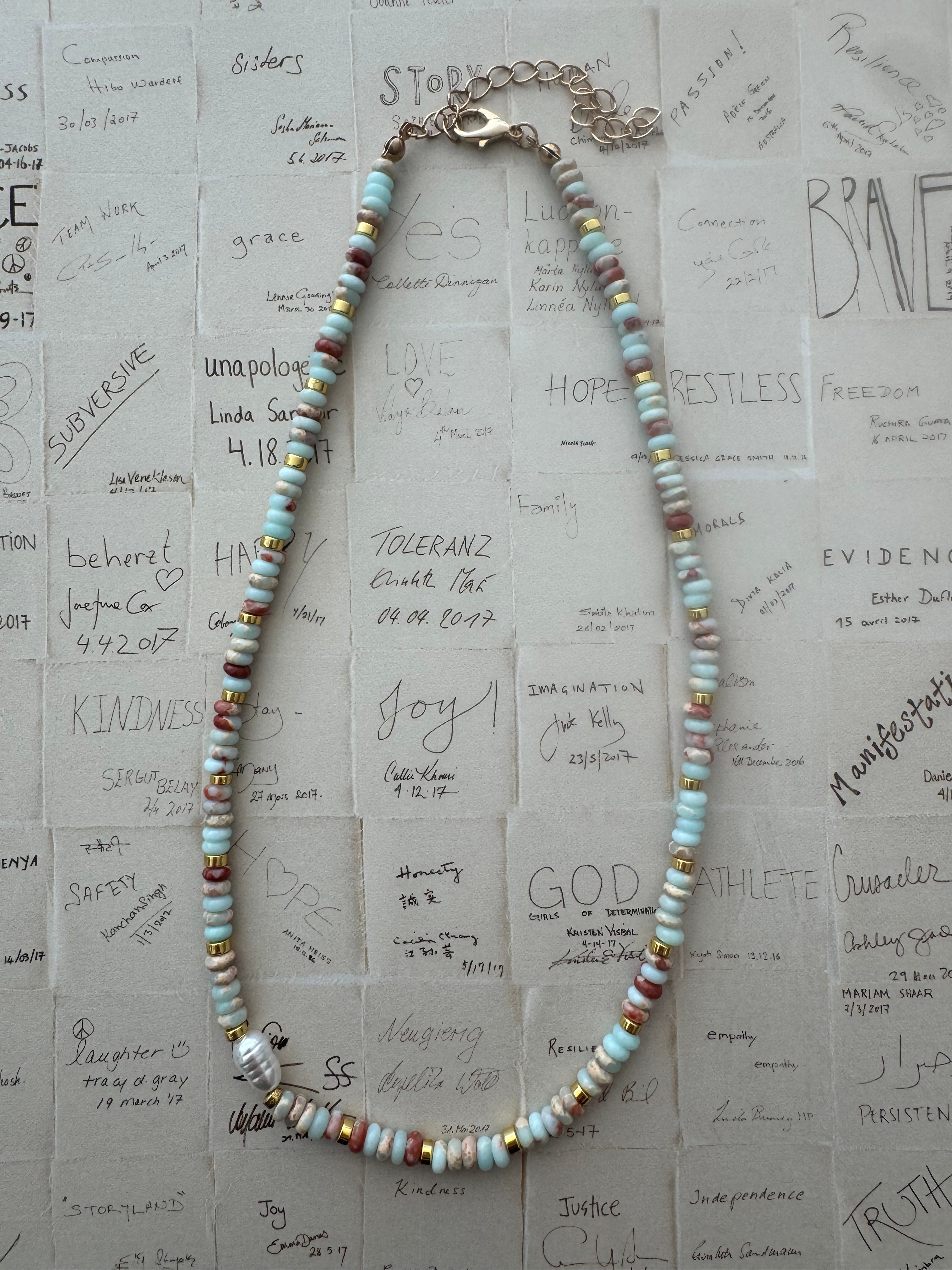 Necklace with multicolored beads on a textured paper background