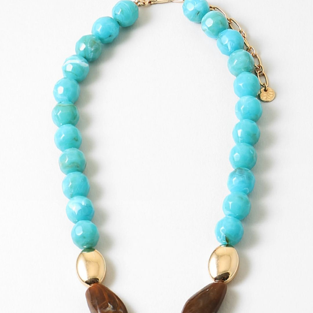 Chunky turquoise beaded necklace with gold and brown bead accents on a white background