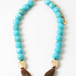 Chunky turquoise beaded necklace with gold and brown bead accents on a white background