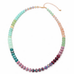 Multicolored green, pink and coral beaded necklace on a white background