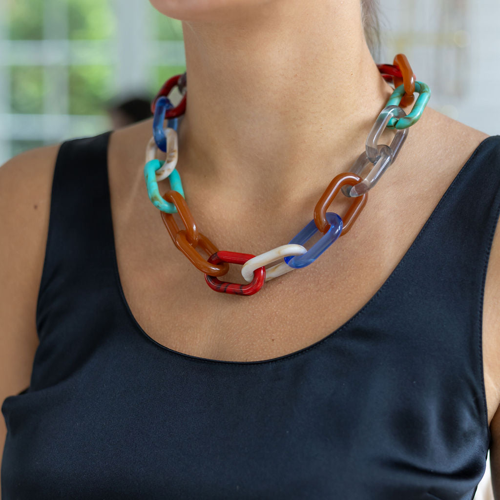 A woman wearing a multi-colored resin link chain necklace