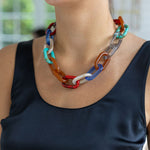 A woman wearing a multi-colored resin link chain necklace