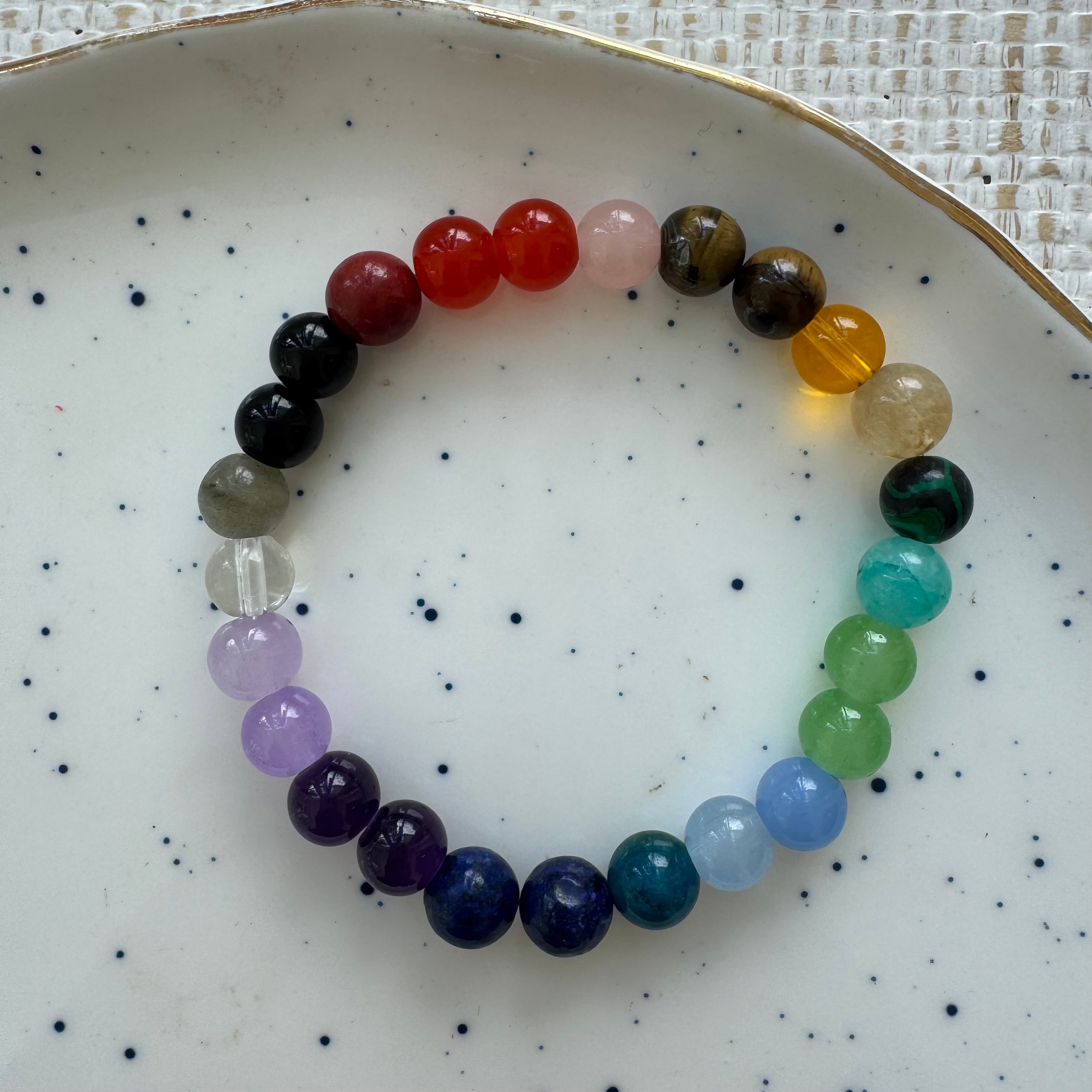 Multicolored beaded bracelet on a speckled ceramic plate