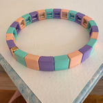 Square bead bracelet in coral, teal and lavender.