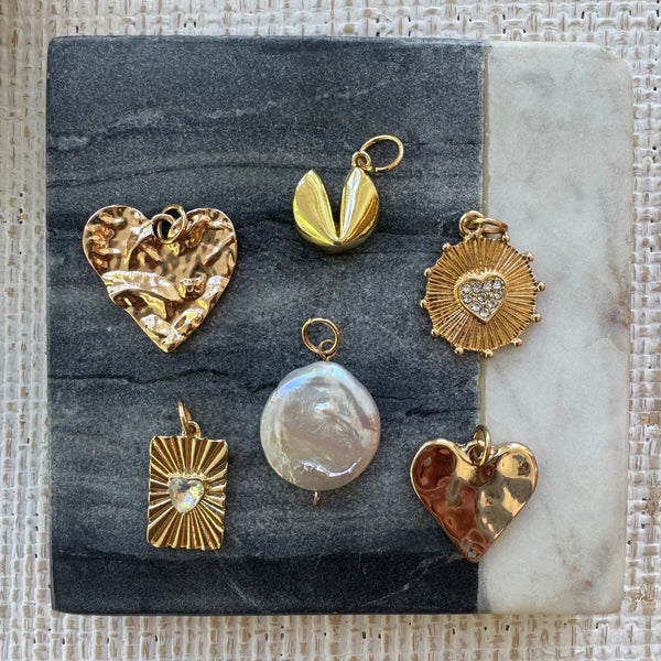 Set of 6 large charms. A hammered gold heart, a gold fortune cookie, a gold disc with a diamond heart, a gold rectangle with a small diamond heart, a large fresh water pearl and another gold hammered Heart.