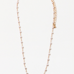 Dainty gold chain necklace with freshwater pearls on a white background