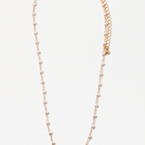 Dainty gold chain necklace with freshwater pearls on a white background