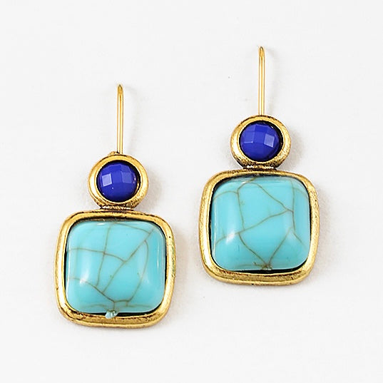 Pair of earrings with gold frames, blue gemstones, and turquoise stones on a white background