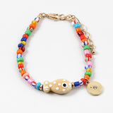 A bracelet with multicolored beads and a gold-colored fish-shaped charm