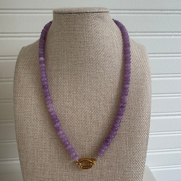 Purple bead necklace with a gold toggle clasp.