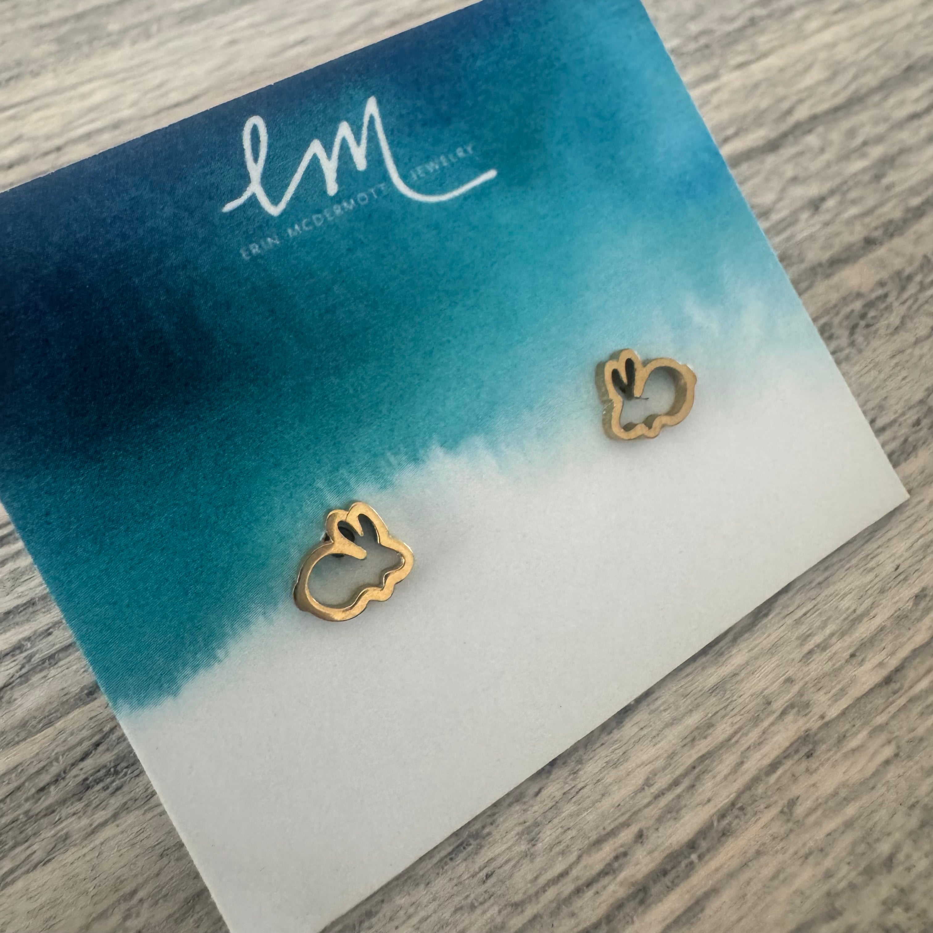Picture of an earring holder that displays two dainty gold outline bunny earrings.