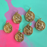 Gold butterfly disc pendants on a colorful abstract background