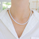 Model wearing an opaque white bead necklace.