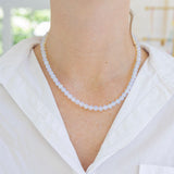 Model wearing an opaque white bead necklace.