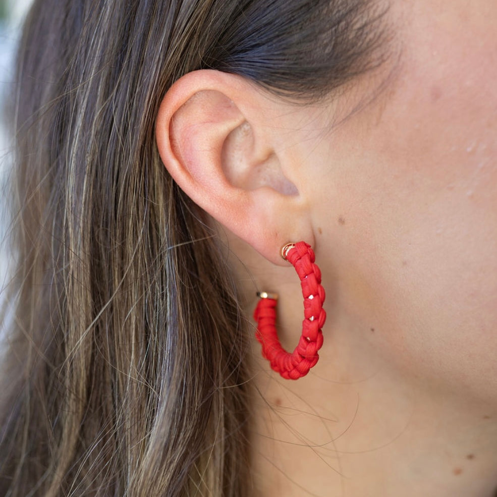 Picture of model wearing a hoop earring that is wrapped in red cord.