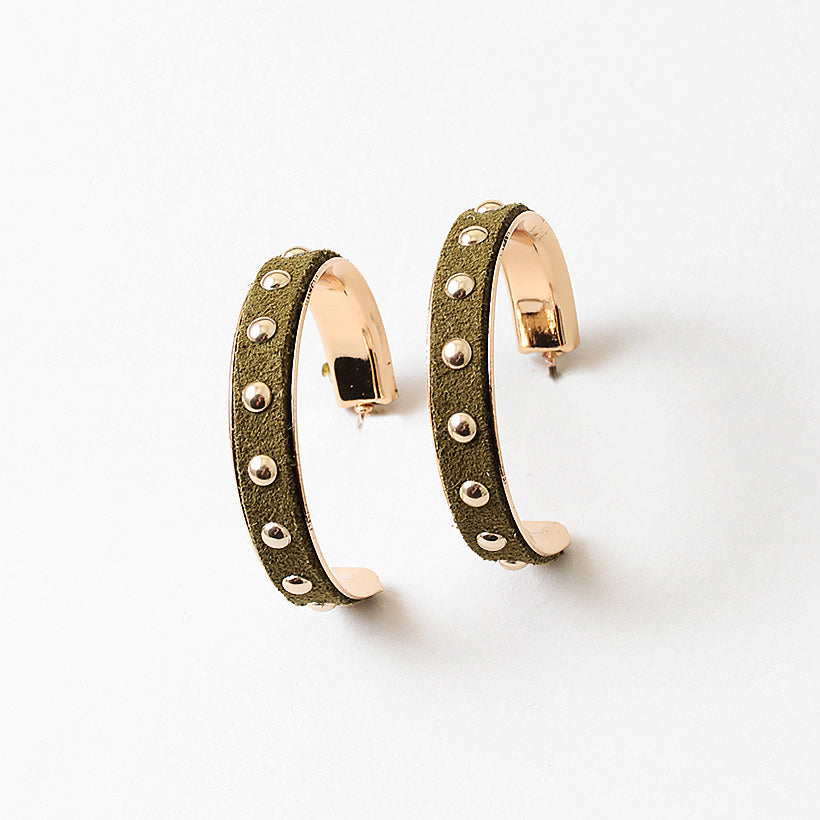 Green suede gold hoop earrings with studded details on a white background